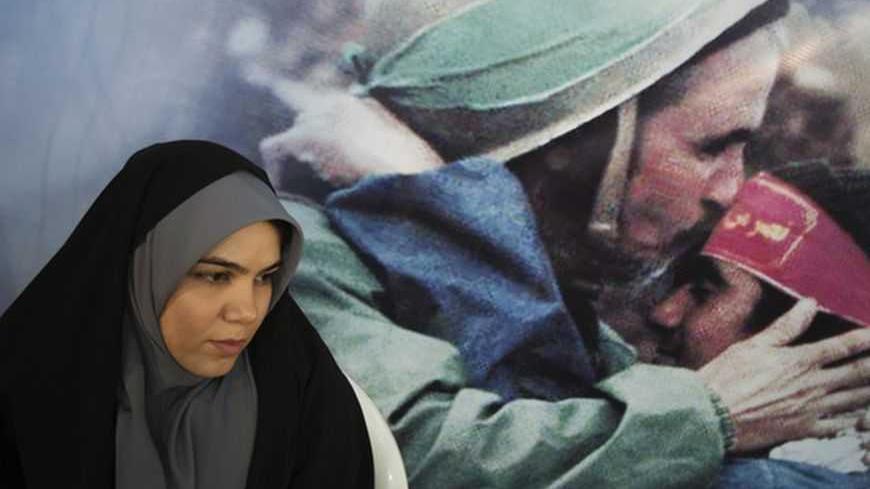 EDITORS' NOTE: Reuters and other foreign media are subject to Iranian restrictions on leaving the office to report, film or take pictures in Tehran.
An election official sits in front of an image of Iranian warriors at a mosque, used as a polling station, during the parliamentary election in central Tehran March 2, 2012. Iranians voted on Friday in a parliamentary election which is expected to reinforce the power of the clerical establishment of Supreme Leader Ayatollah Ali Khamenei over hardline politic
