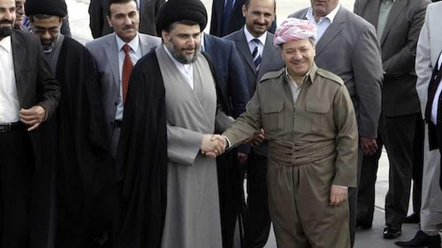 Iraqi Kurdish regional President Masoud Barzani (R) welcomes Iraqi Shi'ite cleric Moqtada al-Sadr at Arbil's airport, about 350 km (220 miles) north of Baghdad April 26, 2012.  REUTERS/Azad Lashkari (IRAQ - Tags: POLITICS) - RTR3194S