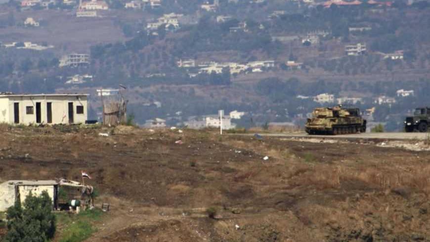 Syrian military vehicles are seen from Aboudiyeh village near the Syrian border, in northern Lebanon, October 9, 2012. REUTERS/Omar Ibrahim (LEBANON - Tags: CIVIL UNREST POLITICS MILITARY) - RTR38Y91
