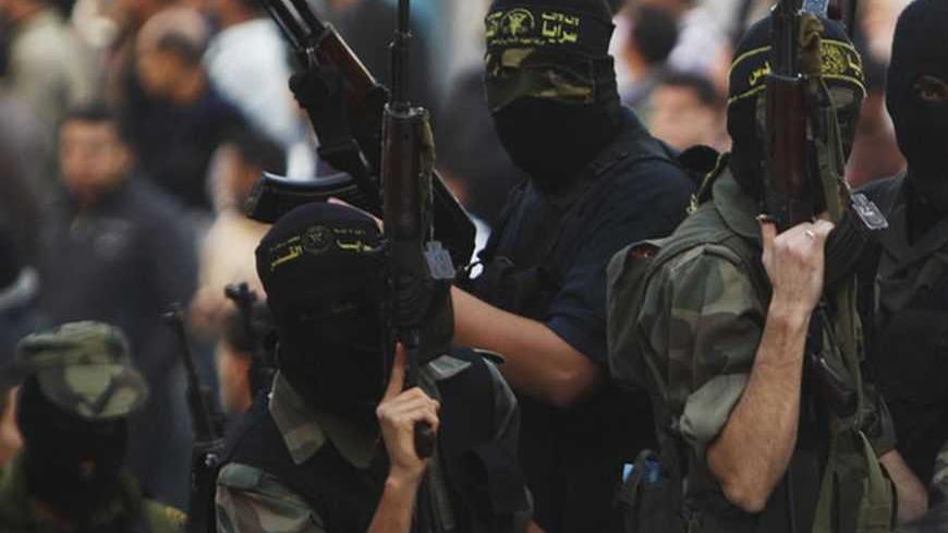 Islamic Jihad militants take part in the funeral of their comrade Mahmoud Shaath in Khan Younis, in the southern Gaza Strip November 28, 2012. Shaath died on Wednesday from a wound he suffered from an Israeli air strike during an eight-day conflict, Palestinian medics said. Eight days of Israeli air strikes on Gaza and cross-border Palestinian rocket attacks ended in an Egyptian-brokered truce agreement a week ago that called on Israel to ease restrictions on the territory. REUTERS/Ibraheem Abu Mustafa (GAZ