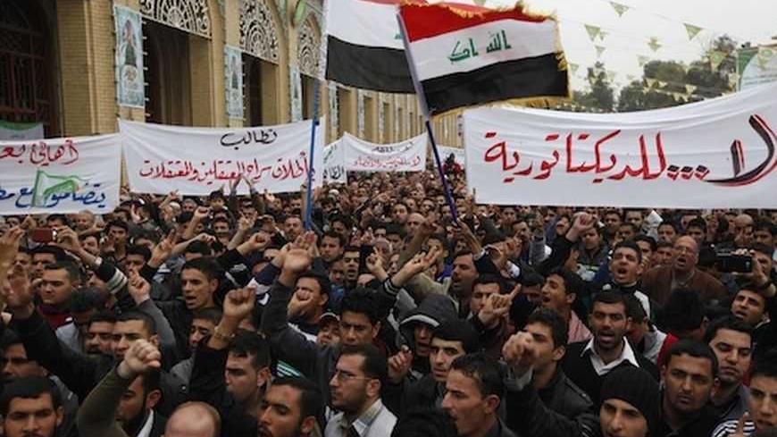Iraqi Sunni Muslims take part in an anti-government demonstration at the Abu Hanifa Sunni mosque in Baghdad's Adhamiya district, January 25, 2013.  At least three people were killed on Friday when Iraqi troops opened fire during clashes in Falluja city with Sunni protesters rallying against Shi'ite Prime Minister Nuri al-Maliki, officials and witnesses said. Banner on right reads, "No to Dictatorship".   REUTERS/Thaier Al-Sudani (IRAQ - Tags: POLITICS RELIGION CIVIL UNREST) - RTR3CXO9