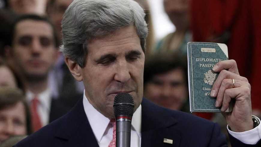 John Kerry, the new U.S. Secretary of State, holds the diplomatic passport he was issued at eleven years old, while greeting employees of the State Department in Washington February 4, 2013. Kerry's father, Richard, was a U.S. Foreign Service officer in Berlin after World War II. REUTERS/Gary Cameron (UNITED STATES - Tags: POLITICS TPX IMAGES OF THE DAY) - RTR3DCG4