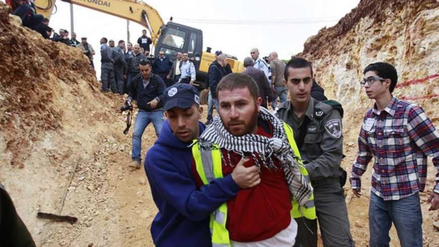 A plainclothes Israeli policeman (L) detains a Palestinian protester during a demonstration against Israel's construction of a road in the Arab neighbourhood of Beit Safafa in Jerusalem February 10, 2013. Some 50 Palestinians protested against the construction of the road, which they claim is an expropriation of their land. REUTERS/Ammar Awad (JERUSALEM - Tags: POLITICS CIVIL UNREST BUSINESS CONSTRUCTION) - RTR3DL5P