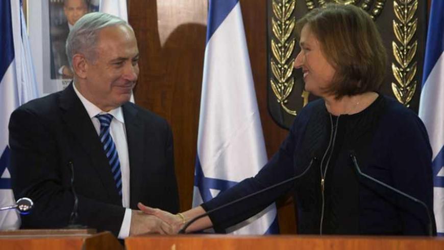 Israel's Prime Minister Benjamin Netanyahu (L) shakes hands with former Foreign Minister Tzipi Livni, head of the centrist Hatenuah party, during their joint statement at the Knesset, the Israeli parliament, in Jerusalem February 19, 2013. Netanyahu took his first step in forming a new government on Tuesday saying he had signed a coalition deal with Livni, who will handle efforts to renew stalled Middle East diplomacy. REUTERS/Ronen Zvulun (JERUSALEM - Tags: POLITICS) - RTR3DZYL