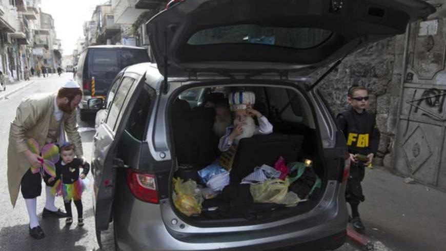 Children wearing costumes for the Jewish holiday of Purim wait to get out of a car in Jerusalem's Mea Shearim neighbourhood February 25, 2013. Purim is a celebration of the Jews' salvation from genocide in ancient Persia, as recounted in the Book of Esther.    REUTERS/Ronen Zvulun (JERUSALEM - Tags: RELIGION) - RTR3E9X6
