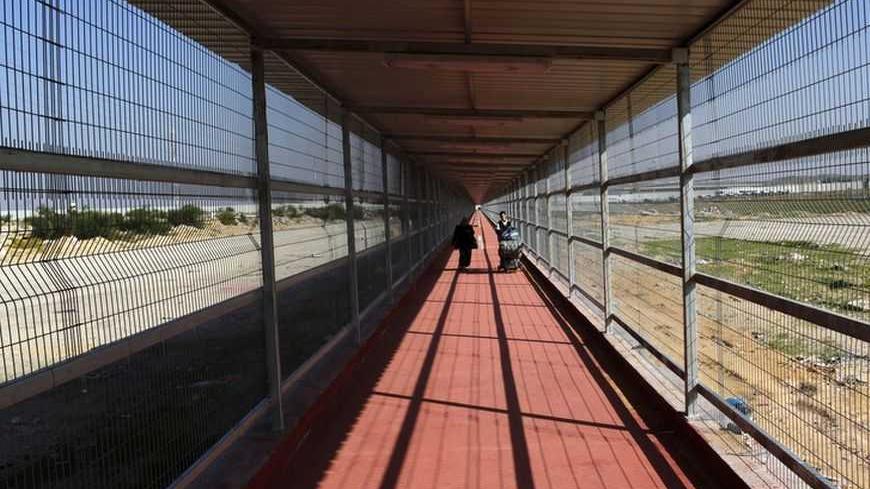 Palestinians walk through a newly built 500 meter-long passage way on their way back to the Gaza Strip through Israel's Erez Crossing December 3, 2009. REUTERS/Yannis Behrakis (GAZA POLITICS) - RTXRERB