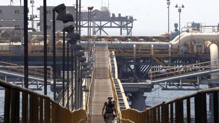 A soldier walks on the platform of the Basra Oil Terminal, 12 nautical miles off the Iraqi coast in the waters of the Northern Arabian Gulf, close to the port town of Umm Qasr August 8, 2006. The terminal is the main source of Iraq's revenues, a key supplier to the global energy market and an obvious target for insurgents aiming to thwart the country's economic recovery. Picture taken August 8, 2006. REUTERS/Thaier Al-Sudani (IRAQ) - RTR1GA9M