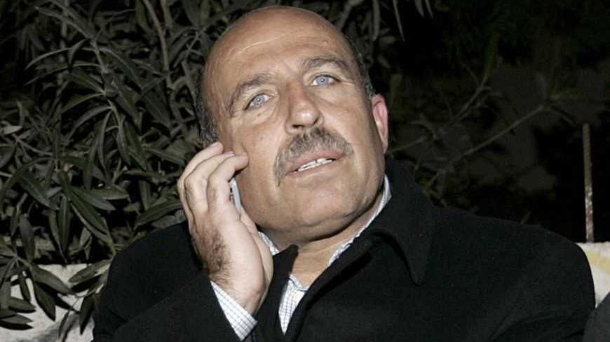 Senior Fatah official Sufian Abu Zaida (C) speaks on the phone after he was freed in Gaza December 18, 2006. The armed wing of the governing Palestinian movement Hamas said it had freed a senior Fatah official who was abducted earlier in the Gaza Strip. REUTERS/Mohammed Salem (GAZA) - RTR1KJKK