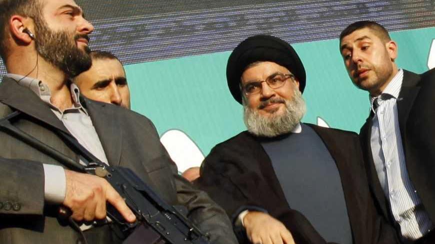 Lebanon's Hezbollah leader Sayyed Hassan Nasrallah (2nd R), escorted by his bodyguards, greets his supporters at an anti-U.S. protest in Beirut's southern suburbs September 17, 2012. Nasrallah made a rare public appearance on Monday to address tens of thousands of marchers protesting against a film made in the United States that mocks the Prophet Mohammad. Nasrallah has been living in hiding to avoid assassination since Hezbollah fought a month-long war with Israel in 2006. REUTERS/Sharif Karim (LEBANON - T