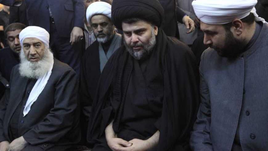 Iraqi Shi'ite cleric Moqtada al-Sadr (C) takes part in Friday prayers participated by Sunni and Shi'ite Muslim worshippers in a gesture of unity at the Abdul Qadir Gilani Mosque in Baghdad January 4, 2013.  REUTERS/Thaier Al-Sudani (IRAQ - Tags: RELIGION) - RTR3C3I0