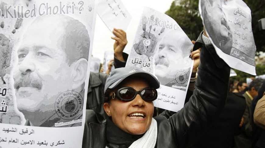 A woman chants slogans and holds pictures of assassinated leftist politician Chokri Belaid during a demonstration against the Islamist Ennahda movement in Tunis February 23, 2013. REUTERS/Zoubeir Souissi (TUNISIA - Tags: CIVIL UNREST POLITICS) - RTR3E69D