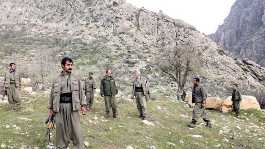 PKK fighters stand guard during the release of eight Turkish prisoners in the northern Iraqi city of Dohuk, March 13, 2013.  Turkish Kurd militants freed a group of Turkish soldiers and officials they had held in the mountains of northern Iraq for more than a year on Wednesday, the first concrete step in efforts to end their 28-year-old insurgency. The six soldiers, a police officer and a local official looked in good health and wore clean clothes as they were handed to a delegation of Turkish rights activi