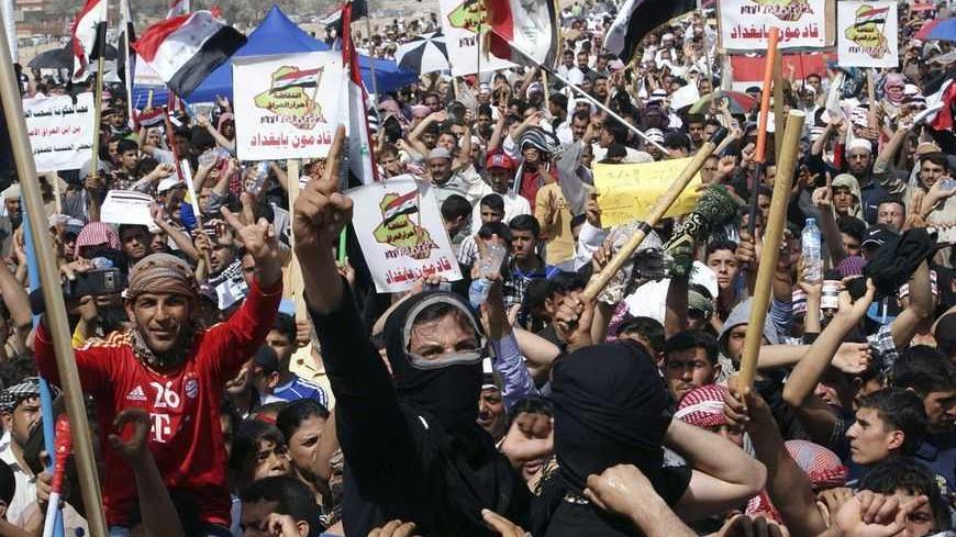 Sunni Muslims shout slogans during an anti-government demonstration in Falluja, 50 km (31 miles) west of Baghdad, March 15, 2013. Thousands of Sunni Muslims protested after Friday prayers in huge rallies against Shi'ite Iraqi Prime Minister Nuri al-Maliki, demanding that he step down. The signs read, "We are coming, Baghdad".                        REUTERS/Mohanned Faisal (IRAQ - Tags: POLITICS CIVIL UNREST) - RTR3F11P