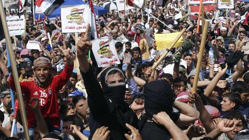 Sunni Muslims shout slogans during an anti-government demonstration in Falluja, 50 km (31 miles) west of Baghdad, March 15, 2013. Thousands of Sunni Muslims protested after Friday prayers in huge rallies against Shi'ite Iraqi Prime Minister Nuri al-Maliki, demanding that he step down. The signs read, "We are coming, Baghdad".                        REUTERS/Mohanned Faisal (IRAQ - Tags: POLITICS CIVIL UNREST) - RTR3F11P
