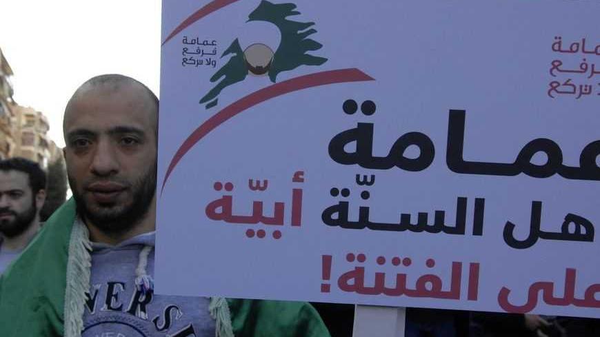 A Sunni Muslim protester carries a banner as he takes part in a protest in the majority Sunni Beirut district of Tariq al-Jadideh against the attacks on Sunni Muslim scholars, March 18, 2013. Four Sunni Muslim scholars were beaten up in two separate attacks in Beirut on Sunday night, testing a fragile peace between the sects and factions that fought Lebanon's 15-year civil war. The sign reads 'The turban of the Sunni Clerics, is superior to strife'. REUTERS/Hussam Shebaro   (LEBANON - Tags: POLITICS CIVIL U