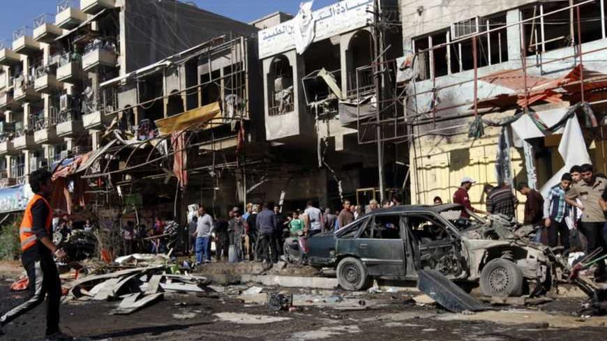 Residents gather at the site of a car bomb attack in the AL-Mashtal district in Baghdad March 19, 2013. A series of coordinated car bombs and blasts hit Shi'ite districts across Baghdad and south of the Iraqi capital on Tuesday, killing at least 25 people on the tenth anniversary of the U.S.-led invasion. REUTERS/Mohammed Ameen (IRAQ - Tags: CONFLICT CIVIL UNREST) - RTR3F6F7
