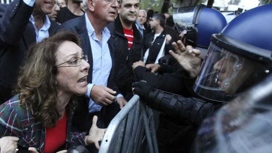 A protester yells at policemen during a protest by employees of Cyprus Popular Bank outside the parliament in Nicosia March 21, 2013. The Cypriot central bank denied reports and frantic rumours on Thursday that stricken Cyprus Popular Bank, the island's second-largest lender, is to be closed down. REUTERS/Andreas Manolis (CYPRUS - Tags: POLITICS BUSINESS CIVIL UNREST TPX IMAGES OF THE DAY) - RTR3FA5X