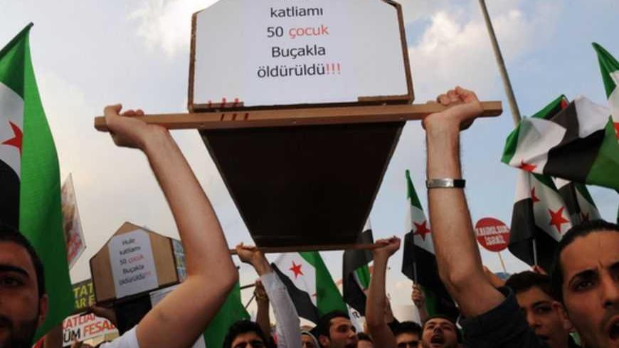 Protestors chant slogans against Israel and Syrian President Bashar al-Assad as they carry a mock coffinwith the mention "In Hule masacre 50 children killed by knives" during a rally on May 31, 2012 on Taksim Square in Istanbul, marking the first anniversary of the death of nine Turks, shot in May 2010 when Israeli naval commandos seized the Turkish ship Mavi Marmara that was part of a flotilla trying to break the Gaza blockade.  The crowd gathered in iconic Taksim Square under the banner of the pro-Islamic