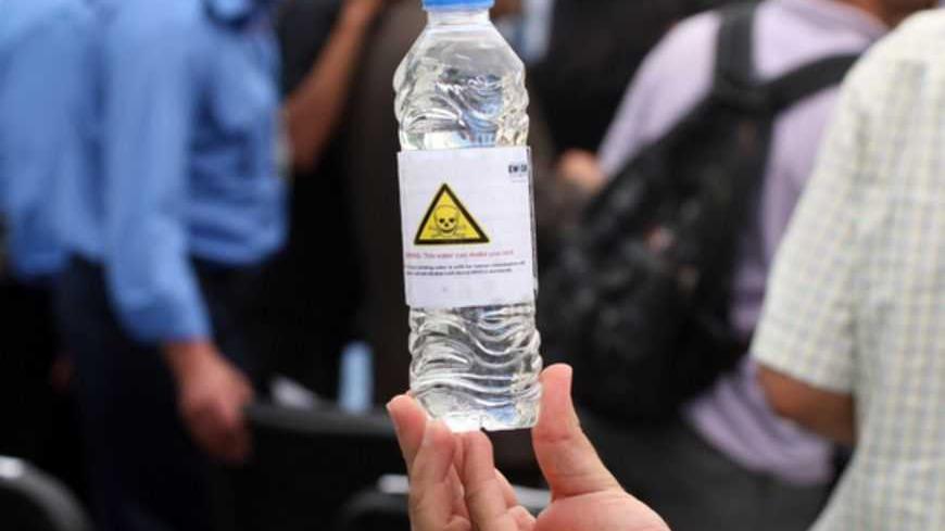 A man holds a bottle filled with water from the Gaza Strip that is unsuitable for drinking during an event in Gaza City on June 14, 2012 as fifty international organizations and UN agencies urged Israel to lift its blockade on the Gaza Strip to mark the fifth anniversary of the strengthening of that measure after the takeover of the Palestinian territory by Hamas. AFP PHOTO/ SAID KHATIB        (Photo credit should read SAID KHATIB/AFP/GettyImages)