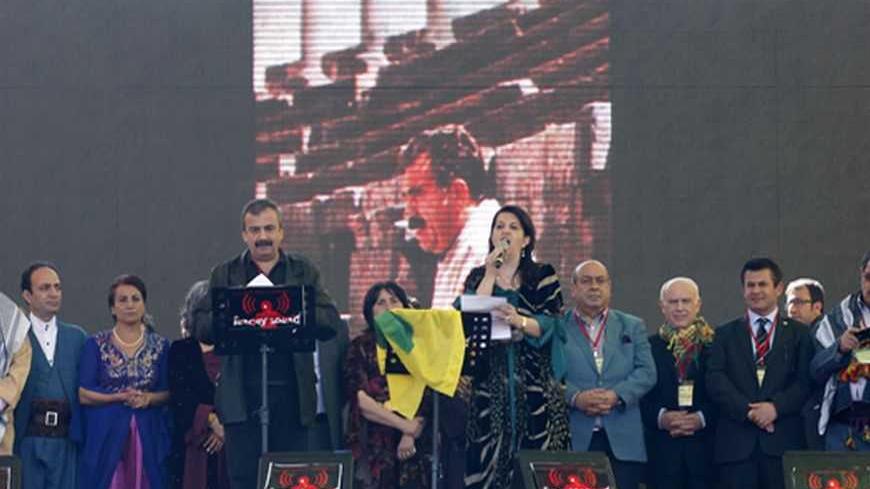 Pro-Kurdish politicians Sirri Sureyya Onder (3rd L) and Pervin Buldan (6th R) read the statement of jailed Kurdish rebel leader Abdullah Ocalan as they are flanked by other Kurdish politicians during a gathering to celebrate Newroz in the southeastern Turkish city of Diyarbakir March 21, 2013. Ocalan ordered his fighters on Thursday to cease fire and withdraw from Turkish soil as a step to ending a conflict that has killed 40,000 people, riven the country and battered its economy. Hundreds of thousands of K