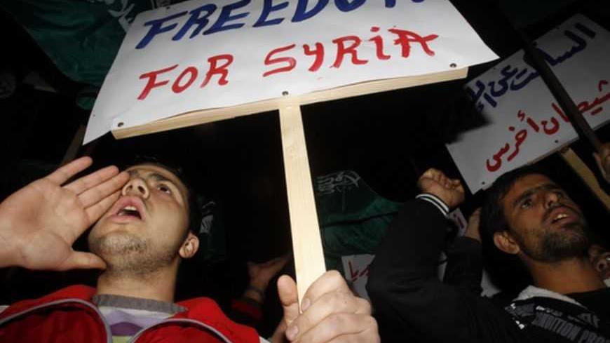 Supporters of Lebanon's Muslim Brotherhood party take part in a rally in the port-city of Sidon, southern Lebanon, against attacks by Syrian President Bashar al-Assad's forces on the Syrian city of Homs February 9, 2012. The placard on right reads: "Silent about the crime, dumb devil". REUTERS/Ali Hashisho (LEBANON - Tags: CIVIL UNREST POLITICS) - RTR2XK8I