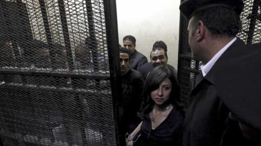 Activists, accused of working for unlicensed non-governmental organizations (NGOs) and receiving illegal foreign funds, stand in a cage during the opening of their trial in Cairo March 8, 2012. An Egyptian judge said on Thursday he was delaying until April 10 the trial of civil society activists including 16 Americans accused of receiving illegal foreign funds and pursuing their pro-democracy activities without a licence. REUTERS/Mohamed Abd El Ghany  (EGYPT - Tags: CIVIL UNREST POLITICS CRIME LAW) - RTR2Z1