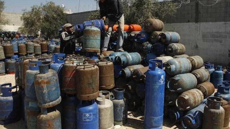 Palestinians arrange gas cylinders at a gas filling station in Khan Younis in the southern Gaza Strip March 22, 2012.  Palestinians in the Gaza Strip are suffering a crisis of dry petrol pumps and frequent blackouts triggered by a fuel supply dispute between Egypt and the enclave's Hamas Islamist rulers. REUTERS/Ibraheem Abu Mustafa (GAZA - Tags: POLITICS ENERGY) - RTR2ZPM8