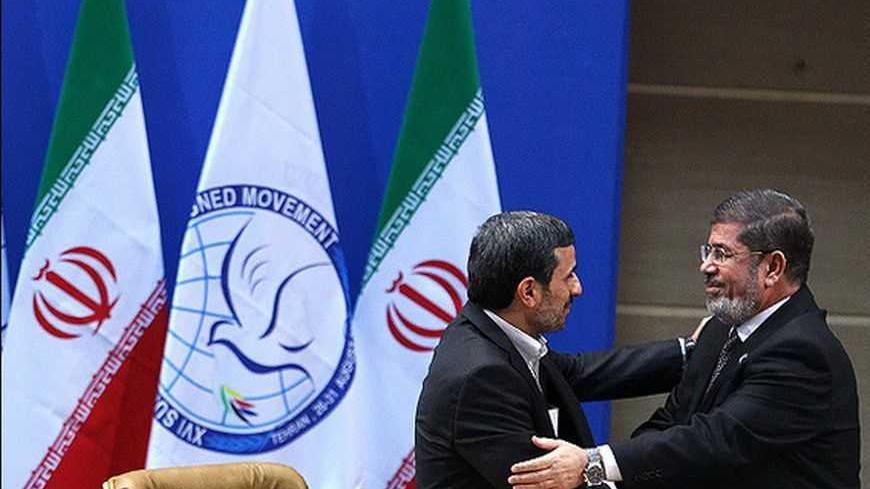 Iranian President Mahmoud Ahmadinejad talks to Egypt's President Mohamed Mursi (R) after his speech during the 16th summit of the Non-Aligned Movement in Tehran, August 30, 2012. REUTERS/Majid Asgaripour/Mehr News Agency (IRAN - Tags: POLITICS) FOR EDITORIAL USE ONLY. NOT FOR SALE FOR MARKETING OR ADVERTISING CAMPAIGNS. THIS IMAGE HAS BEEN SUPPLIED BY A THIRD PARTY. IT IS DISTRIBUTED, EXACTLY AS RECEIVED BY REUTERS, AS A SERVICE TO CLIENTS - RTR379U8