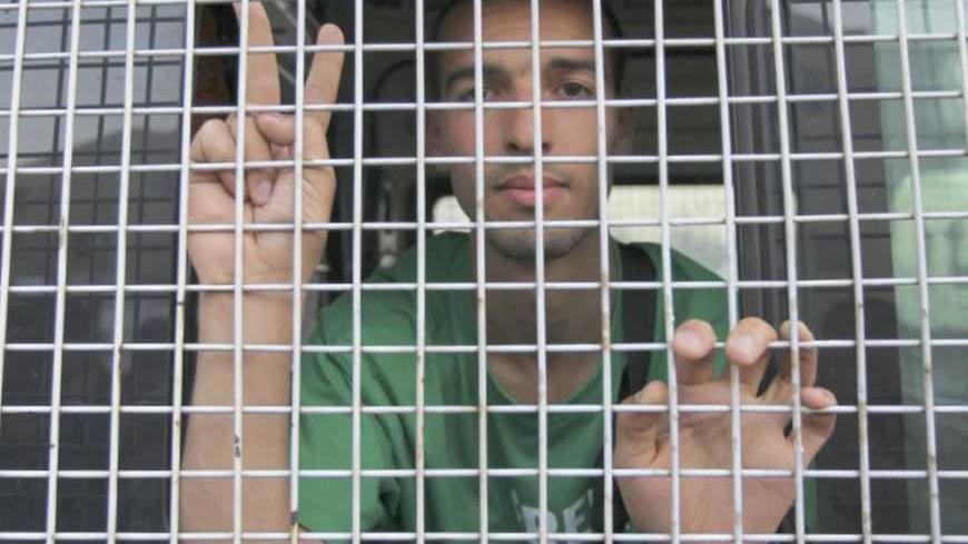 A pro-Palestinian activist flashes the victory sign after being detained by Jordanian police during a demonstration in front of the Israeli embassy in Amman August 30, 2012. Activists protested against Israeli and Jordanian authorities after being barred from entering the West Bank through King Hussein Bridge (Allenby Bridge), around 35 km (22 miles) southeast of the Jordanian capital Amman, to deliver aid to students.  REUTERS/Muhammad Hamed (JORDAN - Tags: POLITICS CIVIL UNREST) - RTR37AIV