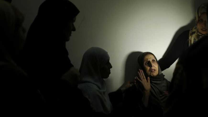 The mother (2nd R) of al-Aqsa TV cameraman Mahmoud Al Kawmy mourns during his funeral in Gaza Strip November 21, 2012. Hospital sources said that two cameramen working for al-Aqsa TV, including  Kawmy, and an educational programming director for the al-Quds channel, both affiliated with Gaza's Hamas government, were killed by Israeli air strikes in their cars on Tuesday. The cameramen were killed in their car not far from the main Shifa hospital in Gaza city while the al-Quds programmer director was killed 