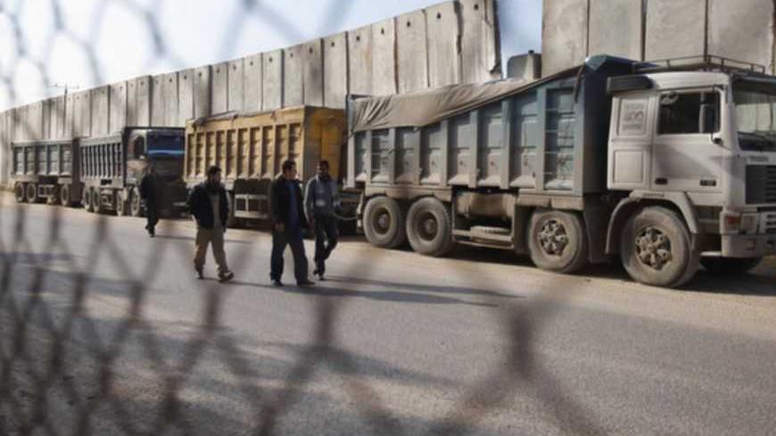 Palestinians walk past trucks loaded with gravel at the Kerem Shalom crossing between Israel and the southern Gaza Strip December 30, 2012. Israel eased its blockade of Gaza on Sunday, allowing a shipment of gravel for private construction into the Palestinian territory for the first time since Hamas seized control in 2007.
REUTERS/Ibraheem Abu Mustafa (GAZA - Tags: POLITICS) - RTR3BZD9