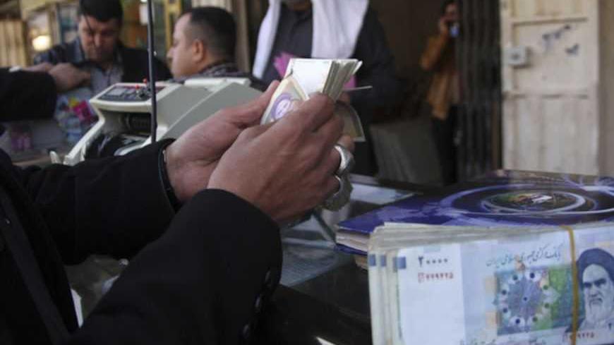 A man counts stacks of Iranian rials on a street in Kerbala, 110 km (68 miles) south of Baghdad January 23, 2013.     REUTERS/Mushtaq Muhammed (IRAQ - Tags: BUSINESS POLITICS) - RTR3CU69