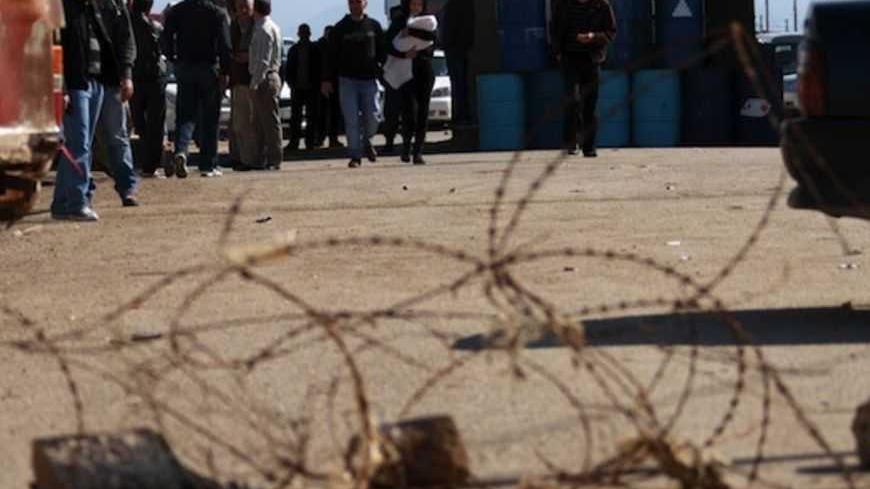 People cross the Lebanese-Syrian border by foot after residents blocked the road in protest against what they said were the sending of diesel to the Syrian goverment, in northern Lebanon February 13, 2013. REUTERS/Omar Ibrahim (LEBANON - Tags: POLITICS CIVIL UNREST) - RTR3DQO6
