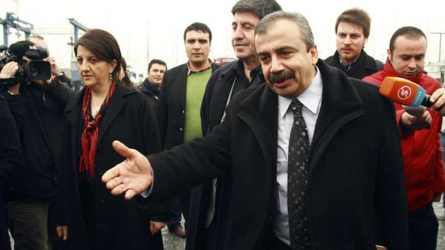Pro-Kurdish politicians Sirri Sureyya Onder (R), Pelvin Buldan (L) and Altan Tan (C), are surrounded by media members before leaving for Imrali island in Istanbul February 23, 2013. A delegation of pro-Kurdish politicians left for Imrali island to meet with imprisoned Kurdistan Workers Party (PKK) leader Abdullah Ocalan. Turkey launched tentative negotiations with PKK leader Ocalan in his jail on Imrali island near Istanbul in October, drawing up a framework to end a conflict which has killed more than 40,0