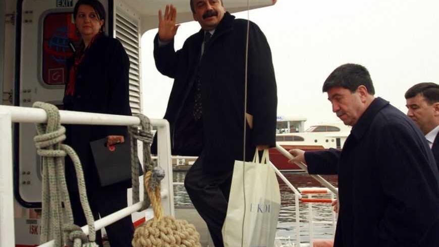 Pro-Kurdish politicians Sirri Sureyya Onder (C), Pelvin Buldan (L) and Altan Tan (R), get on a boat to travel Imrali island in Istanbul February 23, 2013. A delegation of pro-Kurdish politicians left for Imrali island to meet with imprisoned Kurdistan Workers Party (PKK) leader Abdullah Ocalan. Turkey launched tentative negotiations with PKK leader Ocalan in his jail on Imrali island near Istanbul in October, drawing up a framework to end a conflict which has killed more than 40,000 people. The delegation,
