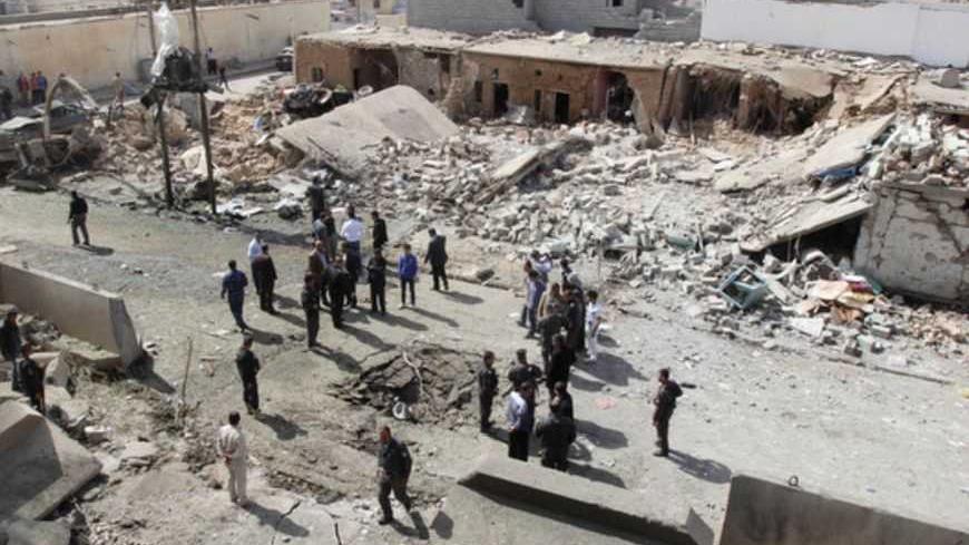 Security personnel and residents gather around a crater caused by a suicide car bomb attack in Debis, west of Kirkuk March 11, 2013. Three civilians were killed and some 70 others were wounded when a suicide car bomb went off on Monday, west of the ethnically mixed northern Iraqi city of Kirkuk, police and hospital sources said. A large number of school pupils were wounded in the attack, which reduced a number of houses to rubble and damaged about ten cars.   REUTERS/Ako Rasheed (IRAQ - Tags: CIVIL UNREST P