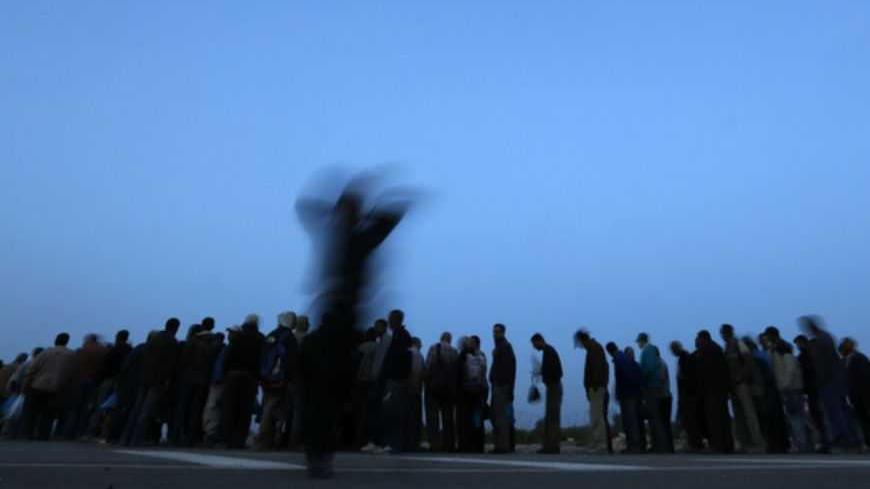 Palestinian labourers wait in line to cross into Israel at dawn at Hashmonaim checkpoint near the West Bank village of Nilin, west of Ramallah March 14, 2013. Israel's system of checkpoints and restrictions in the occupied West Bank inflicts long-term damage on Palestinians' ability to compete in the global market, the World Bank said on Tuesday. REUTERS/Darren Whiteside (WEST BANK - Tags: POLITICS BUSINESS EMPLOYMENT) - RTR3EYTU