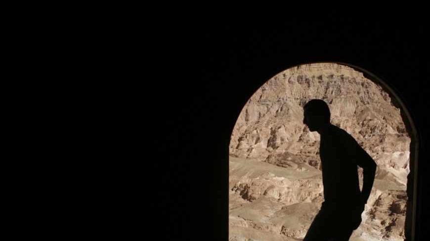 A Bedouin stands in front of a coffee shop overlooking Coloured Canyon in the Sinai Peninsula near the town of Nuweiba March 2, 2007. The 800 metre (0.5 miles) long rock formation consists of sandstone, limestone, granite and veins of basalt. REUTERS/Goran Tomasevic (EGYPT) - RTR1N0X1