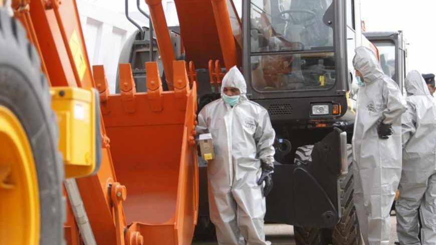 Environmental protection police examine radioactive contaminated vehicles imported from Japan at Umm Qasr's port near Basra, 420 km (260 miles) southeast of Baghdad, November 16, 2011. Sixteen vehicles imported from Japan were found to be contaminated with radiation, Iraq's Ministry of Environment said on Wednesday. Picture taken November 16, 2011. REUTERS/Atef Hassan (IRAQ - Tags : - Tags: ENVIRONMENT DISASTER) - RTR2U4M9
