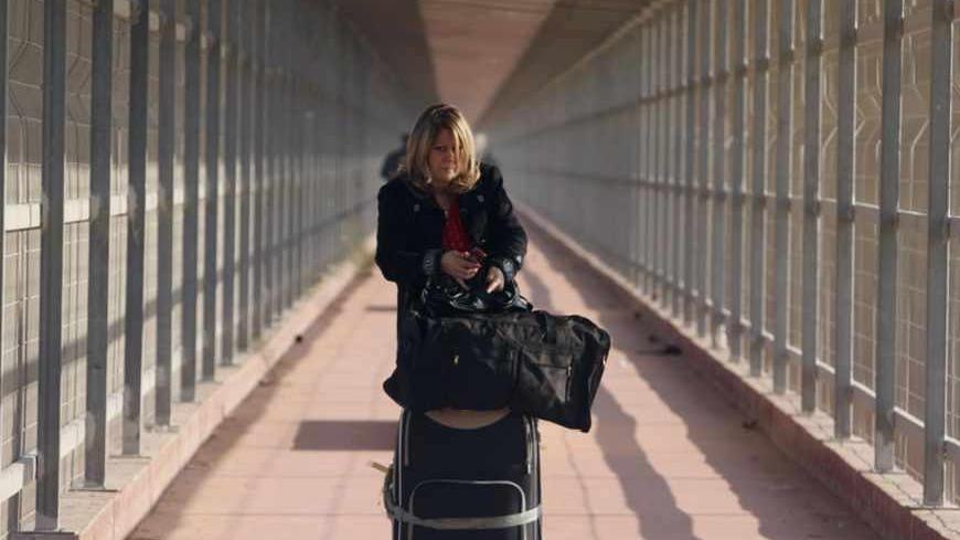 A Christian Palestinian woman leaves Erez border crossing in the northern Gaza Strip December 22, 2011, as she makes her way to the West Bank town of Bethlehem to celebrate Christmas. The Israeli army on Thursday gave permits to some 500 Christian Palestinians from Gaza to enter Israel as they make their way to Bethlehem to celebrate Christmas. REUTERS/Ibraheem Abu Mustafa (GAZA - Tags: POLITICS RELIGION) - RTR2VJM0