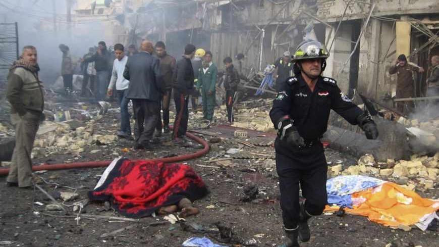 Iraqi civil defence personnel and people gather at the site of a bomb attack in Baghdad's northwestern Kadhimiya district January 5, 2012. A set of explosions involving two car bombs in Kadhimiya killed at least 15 people and wounded 32, police and hospital sources said. Bomb attacks targeting Shi'ite Muslim areas of Iraq killed at least 67 people on Thursday, police and hospital sources said, ramping up fears of an increase in sectarian strife.  REUTERS/Stringer (IRAQ - Tags: CONFLICT CIVIL UNREST CRIME LA