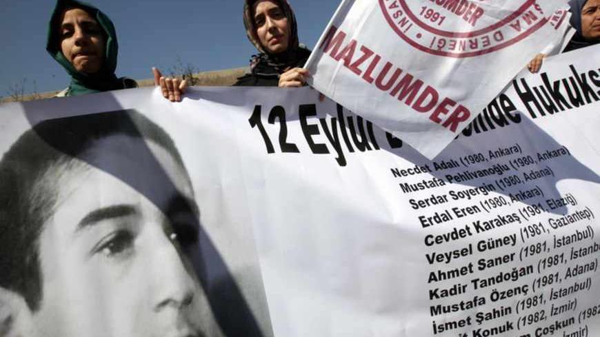 Human rights activists hold a banner with a portrait of Erdal Eren, a leftist executed during the military rule after the coup in 1980, as they demonstrate in front of a courthouse in Ankara April 4, 2012. Thousands of mainly leftist protesters gathered outside the court, waving flags and shouting slogans demanding justice and the prosecution of more than just the coup ring-leaders. More than 30 years after the September 12, 1980 military takeover, the Ankara court began hearing the case against 94-year-old