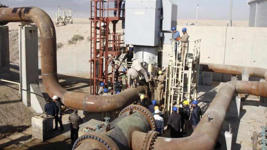 Employees of the state-run South Oil Company (SOC) join a new oil storage tank to the oil pipelines near the southern city of Basra January 14, 2013. The head of the state-run South Oil Company said the new facility will add a capacity of one million barrels to the existing 5.5 million barrels available. REUTERS/Atef Hassan (IRAQ - Tags: ENERGY CIVIL UNREST) - RTR3CG6G