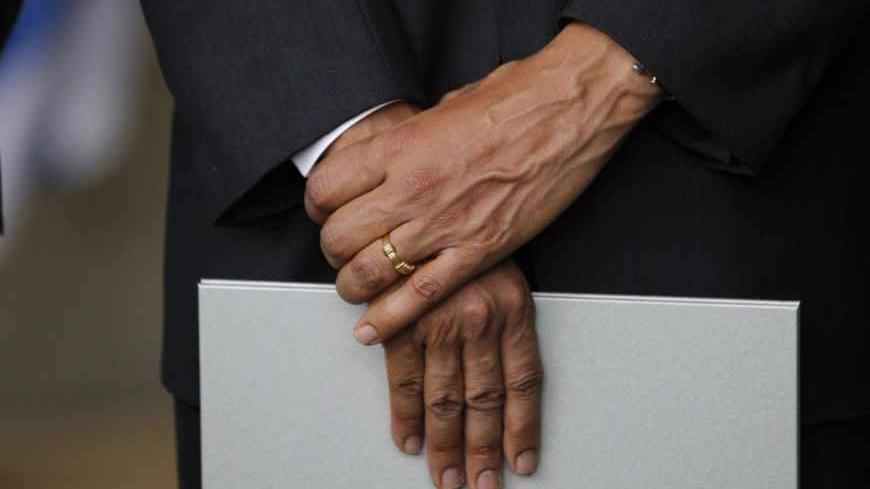 U.S. President Barack Obama holds a souvenir book presented to him by Chairman of the Yad Vashem Directorate Avner Shalev during Obama's visit to the Yad Vashem Holocaust Memorial in Jerusalem, March 22, 2013.    REUTERS/Jason Reed   (JERUSALEM - Tags: POLITICS) - RTR3FBHE