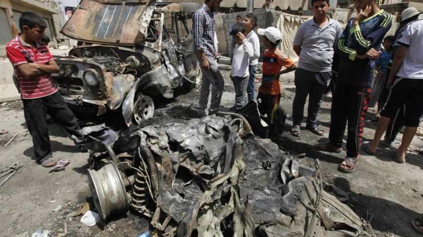Residents gather at the site of a car bomb attack in the Kamaliya district in Baghdad April 15, 2013. Car bombs and attacks on cities across Iraq, including two blasts at a checkpoint at Baghdad international airport, killed at least 20 people and wounded more than 200 on Monday, police said. The wave of attacks in Baghdad, Kirkuk, Tuz Khurmato and other towns to the north to south, came days before Iraqis vote in provincial elections that will test political stability more than a year after U.S. troops lef