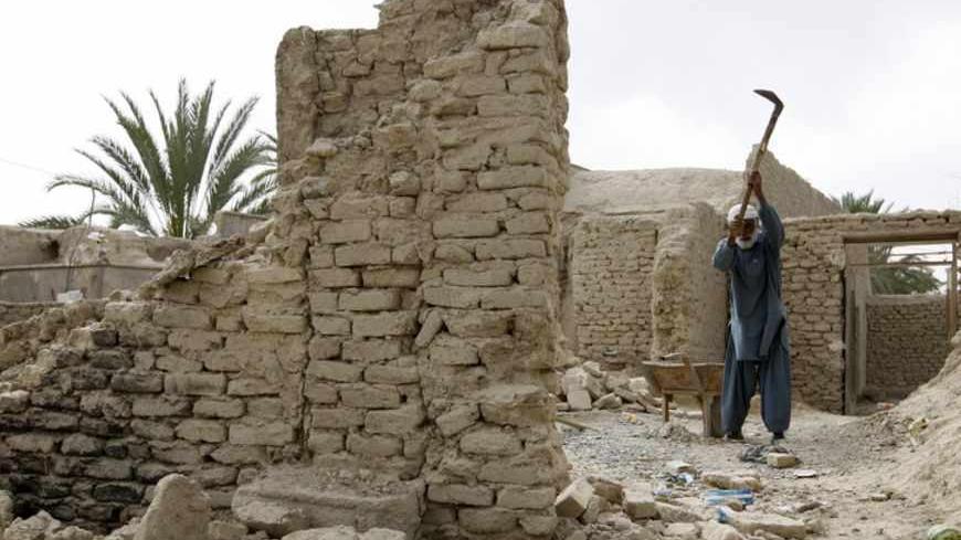 A man works at his house after an earthquake in Saravan, about 1,400 km (869 miles) southeast of Tehran, in this April 18, 2013 photo taken during government tour to affected areas. A powerful earthquake struck a border area of southeast Iran on Tuesday killing at least 35 people in neighbouring Pakistan, destroying hundreds of houses and shaking buildings as far away as India and Gulf Arab states. Picture taken April 18, 2013. REUTERS/Raheb Homavandi  (IRAN - Tags: DISASTER) - RTXYS0N