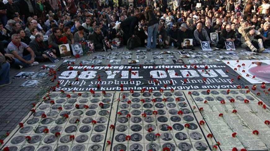 Human rights activists sit behind pictures of Armenian victims at Taksim square in central Istanbul April 24, 2013, during a demonstration to commemorate the 1915 mass killing of Armenians in the Ottoman Empire. REUTERS/Osman Orsal (TURKEY - Tags: ANNIVERSARY POLITICS CIVIL UNREST) - RTXYYD8
