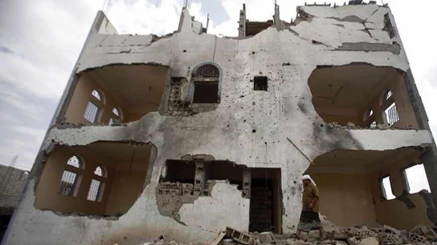 A tribesman walks near a building damaged last year by a U.S. drone air strike targeting suspected al Qaeda militants in Azan of the southeastern Yemeni province of Shabwa February 3, 2013. U.S. drones have launched almost daily raids on suspected al Qaeda militants in Yemen over the past two weeks, and air strikes have aggravated discontent among Yemenis, who say the strikes pose a threat to civilians. REUTERS/Khaled Abdullah (YEMEN - Tags: POLITICS CIVIL UNREST MILITARY SOCIETY) - RTR3DAZJ
