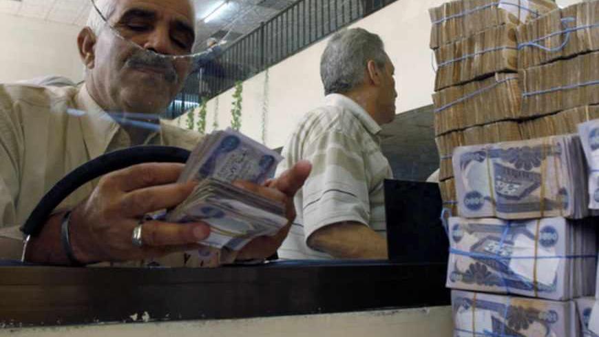 A client counts his money at Al-Rafidain bank in BaghdadJune 21, 2009. Total bank deposits in February -- the latest figures  available -- jumped by half to 36.6 trillion Iraqi dinars ($31 billion) from a year before, and loans surged 65 percent to 5.1 trillion dinars over the same period, central bank data show. 
 To match feature IRAQ/BANKS   REUTERS/Bassim Shati (IRAQ CONFLICT BUSINESS) - RTR2559B