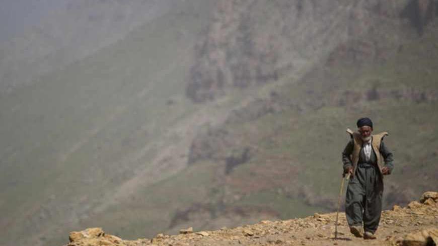 An Iranian Sunni Kurd walks along a mountain in Ouraman Takht village in Kurdistan province, about 620 km (385 miles) west of Tehran, May 12, 2011. Iranian Shi'ite and Sunni Kurds live in harmony with each other in Ouraman Takht, although Sunni is the religion of the majority of the people. REUTERS/Morteza Nikoubazl (IRAN - Tags: RELIGION SOCIETY IMAGES OF THE DAY) - RTR2MC61